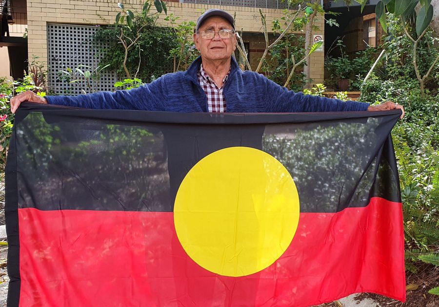 Aboriginal Elder holding the Aboriginal flag